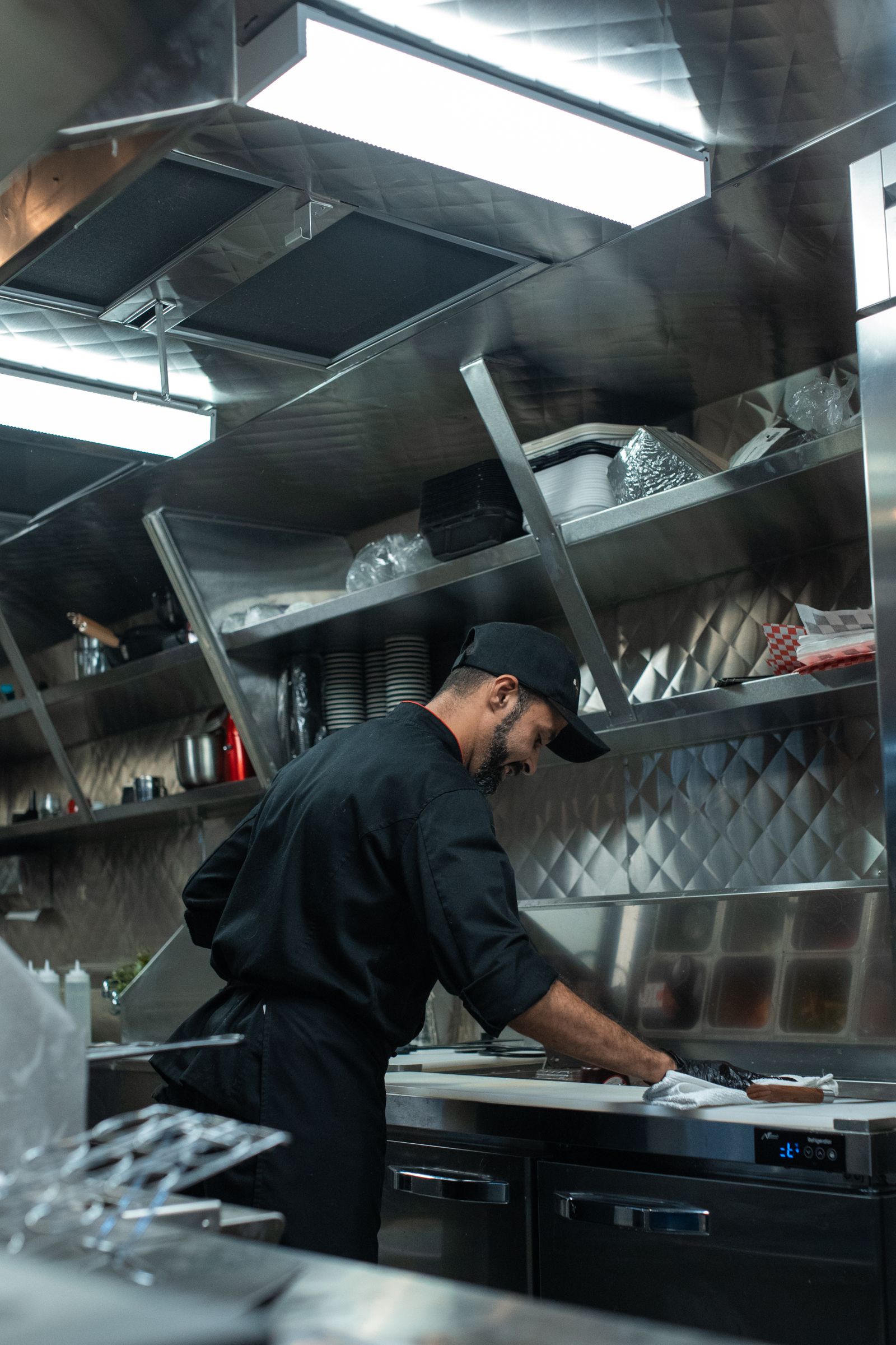 Cozinha profissional com bancadas e prateleiras em inox